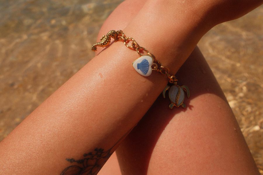 Goudkleurige stainless steel bedelarmband om een pols