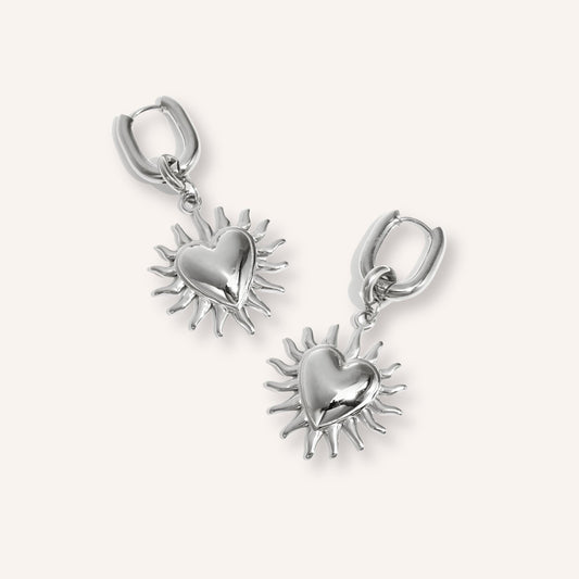 Alba Oorbellen in zilver, zilverkleurige oorbellen met hangende hartjes en zonnemotief