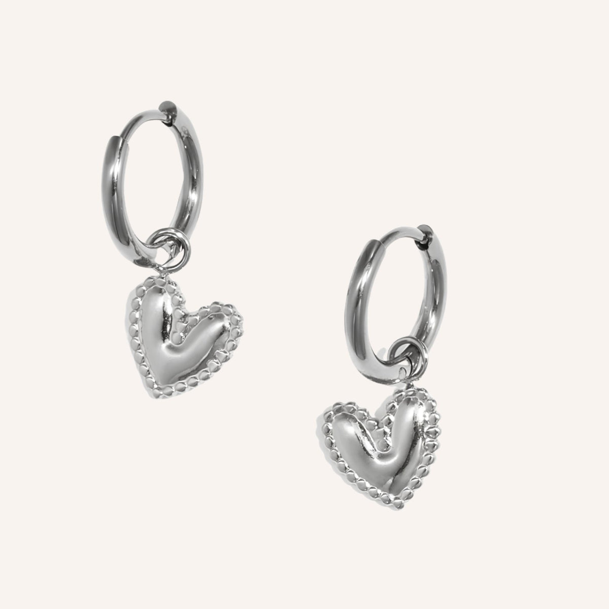 Pralina Oorbellen in zilver, kleine zilverkleurige oorringetjes met hangend hartje