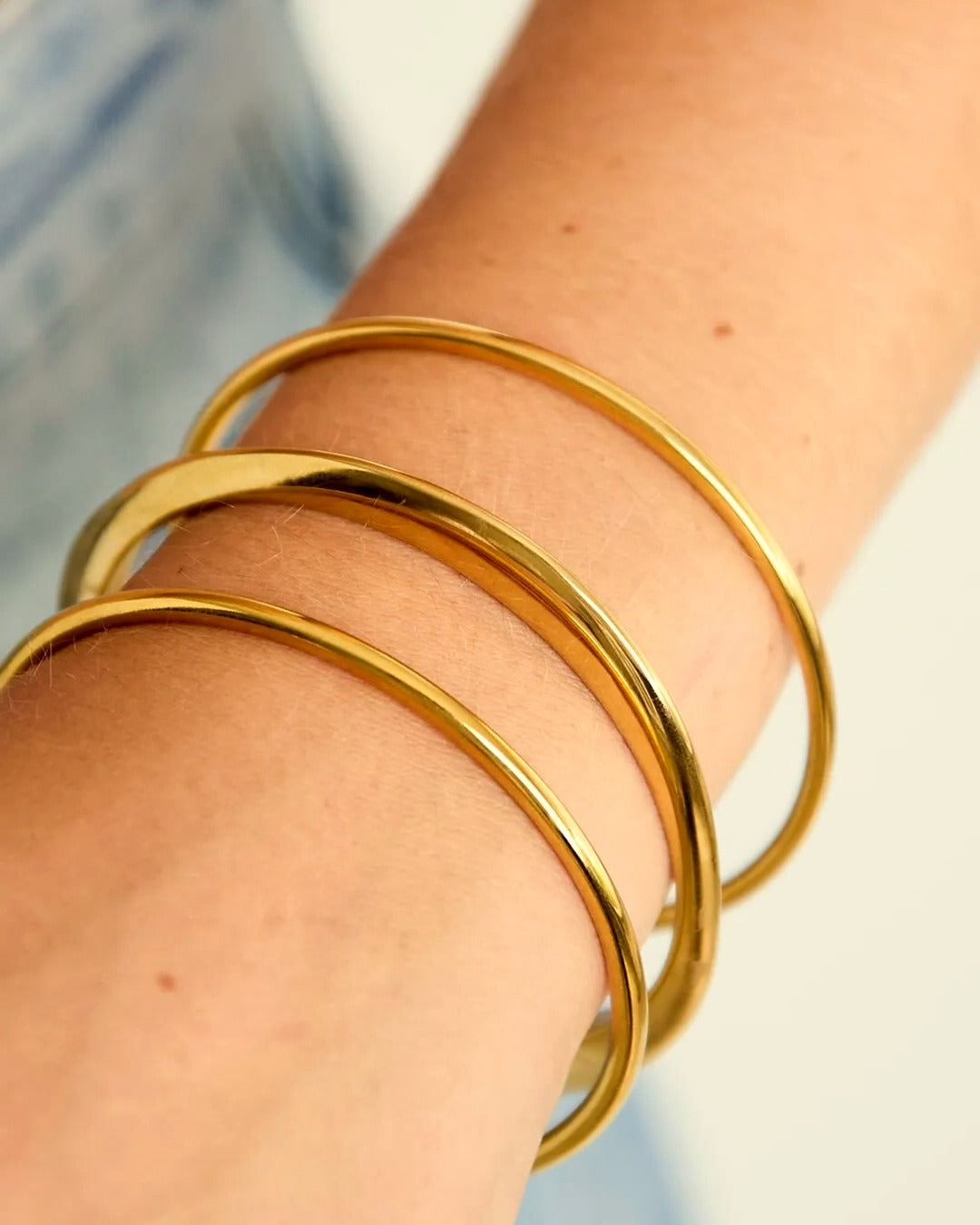Ondulata Armband gedragen, goudkleurige bangles